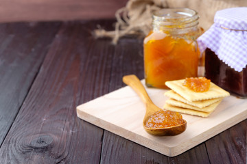 Orange jam on wooden background