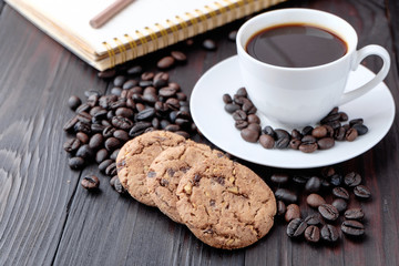 Coffee cup and coffee beans on wooden background