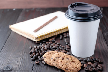 Coffee cup and coffee beans on wooden background