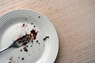 Top view of white plate with fork on it.