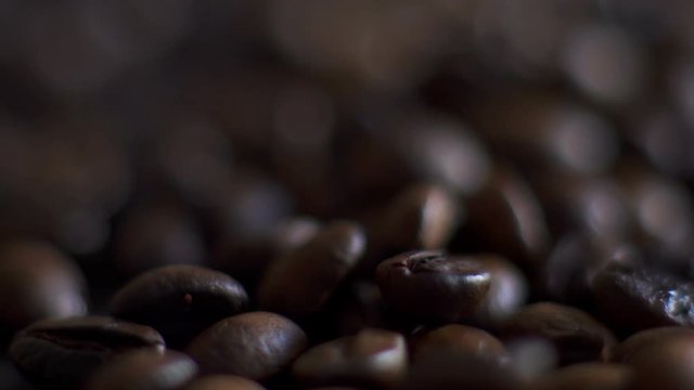 Roasting coffee beans with smoke on dark background