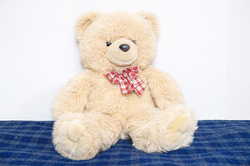 Teddy bear big toy portrait, childhood concept, friend and buddy, brown color, sitting on bed