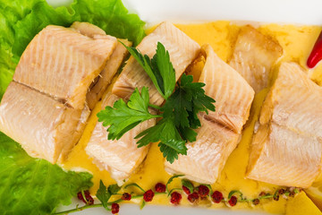 Dish of fish with greens and lemon isolated