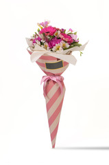 carnation and gerbera in a paper bouquet tied ribbon on a white background. Valentine's Day