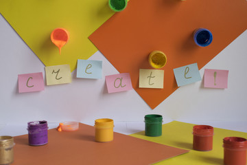 concept of creativity, color papers and paints, with word Create written on notes.