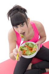 young brunette sporty woman eats salad