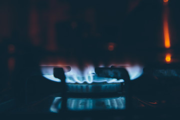 lit burner on the gas stove in the dark