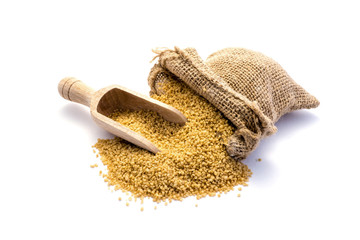 Couscous mit Schaufel und Jutesack isoliert auf weiß