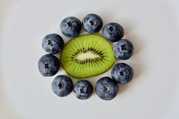 Kiwi and blueberry flower on the white plate