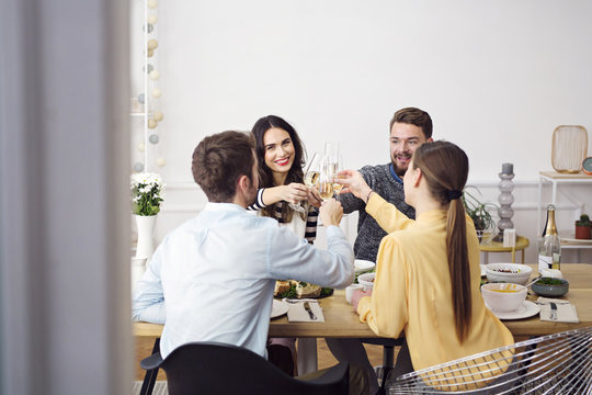 Friends Toasting Champagne Flutes At Lunch Party