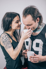 the guy in the dark tattoo and the girl drinking tea on white background