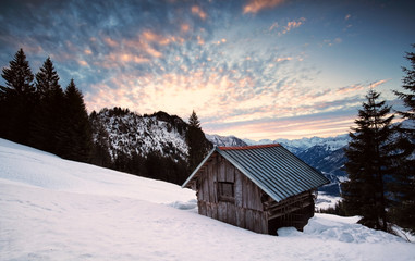 wooden alpine hut in winter mountains