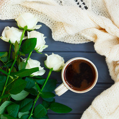 Obraz na płótnie Canvas Cup of black coffee, white knitted plaid and white roses, on dar