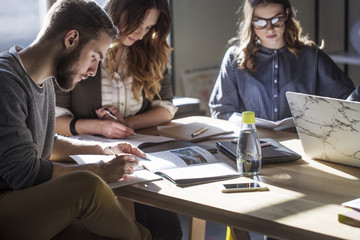 College students studying at table in classroom