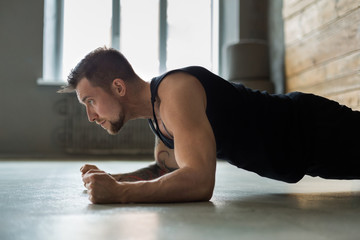 Young man fitness workout, elbow plank