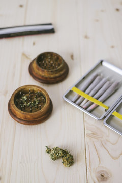 High angle view of marijuana joints with crusher on table