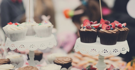 Beautiful cupcakes with berries closeup on banquet table.