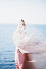Fototapeta na wymiar beautiful girl in a pink dress of tulle and satin of the sea