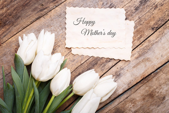 Happy mothers day card with tulips on wooden background