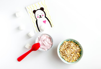 concept kid breakfast with yogurt top view white background