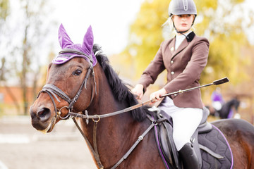 Young jockey girl riding horse on equestrian sport competition