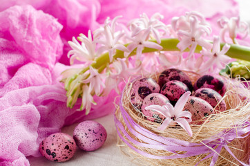 Easter eggs in a nest on a light pink or white