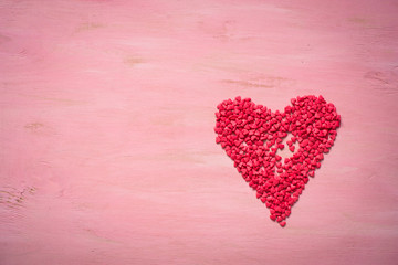 Red heart on pink wooden background. Love and Valentine day symb