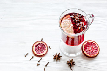 mulled wine with spices in cup on wooden background
