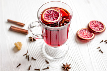 mulled wine with spices in cup on wooden background