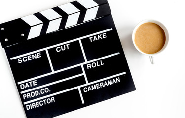Screenwriter desktop with movie clapper board white background top view