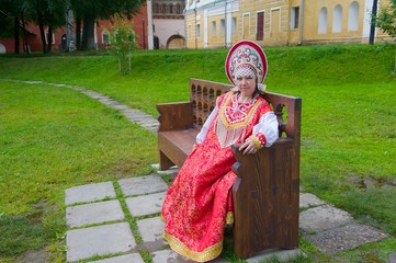 женщина в старинном наряде на скамейке
