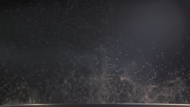 Slow Jet of steam and small drops  from a pan. Steam rising white smoke on black background