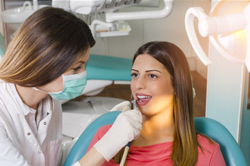 Fototapeta premium Beautiful young adult woman at dentist 