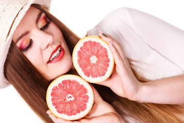 Woman holds two halfs of grapefruit citrus fruit in hands