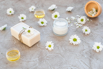 organic cosmetics with camomile on stone background