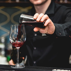 Barman pouring vine into glass in detail