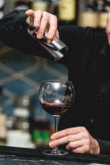 Barman pouring vine into glass in detail