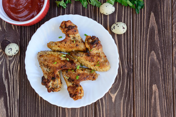 Chicken wings with onion on wooden background