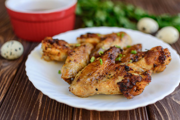 Chicken wings with onion on wooden background