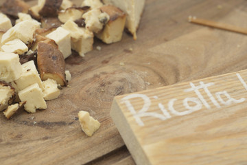 ricotta affumicata tagliata a tocchetti servita su asse di legno
