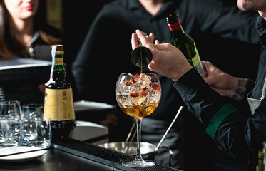 bartender making refreshing coctail with strawberries isolated on a bar background