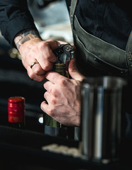Opening a wine bottle with corkscrew in a bar