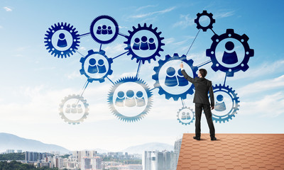Businessman on house roof presenting teamwork and connection concept. Mixed media