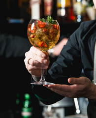 bartender making refreshing coctail with strawberries isolated on a bar background