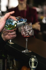 bartender making refreshing pink coctail with a rose on top isol