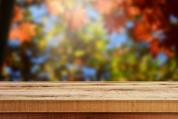 Wooden table and blur autumn forest background