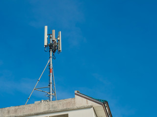 Mobile antenna in the roof of a building, against blue sky