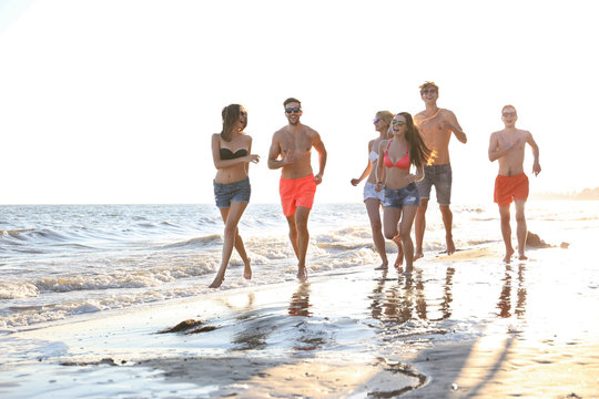 Happy Friends Running On Beach