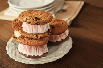Obraz na płótnie Canvas Ice cream cookie sandwiches on plate on wooden background