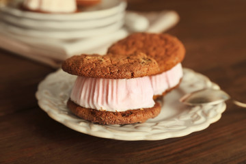 Ice cream cookie sandwiches on plate on wooden background